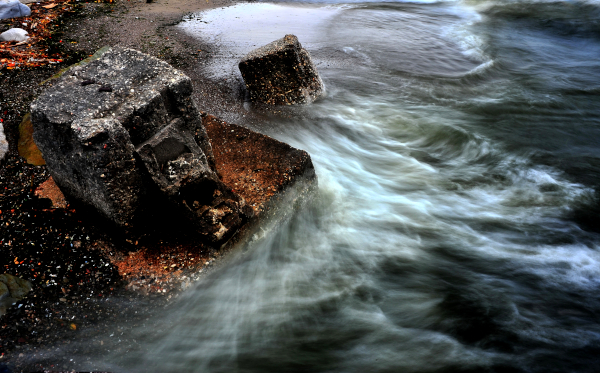 Picture of waves washing over rocks it takes time to erode them.
