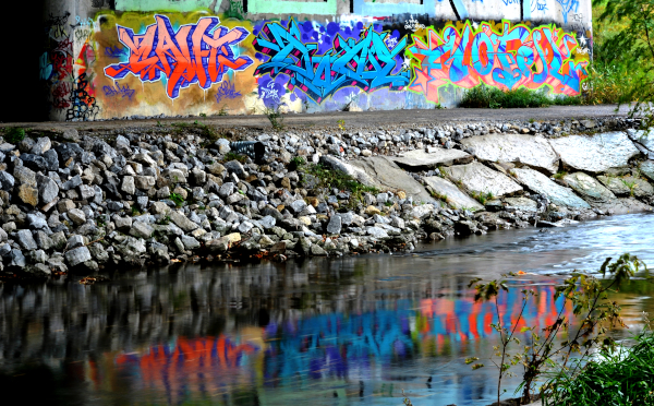 Graffiti found in nature. This photo shows the art displayed on the wall support under a major highway.